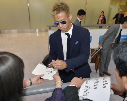 成田空港に到着し、ファンの求めに応じてサインする本田圭佑