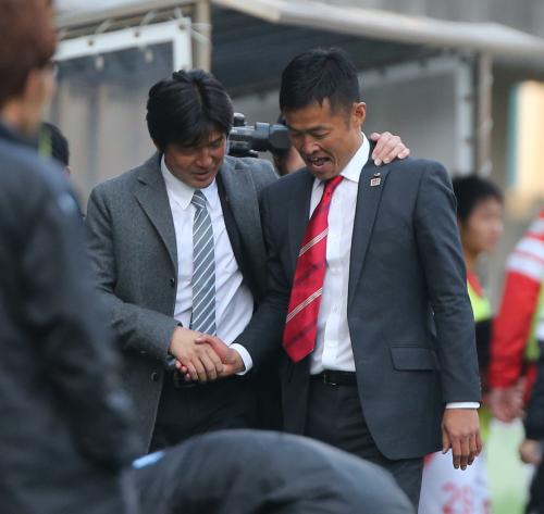 ＜磐田・名古屋＞試合後、初勝利を飾った名古屋・小倉監督（右）が磐田・名波監督に祝福される