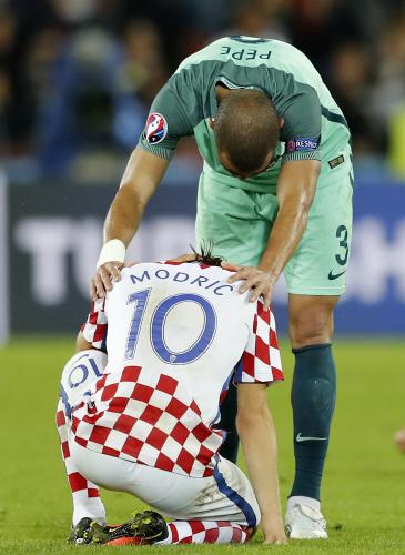 試合後、ピッチに崩れ落ちるクロアチアのモドリッチを慰めるポルトガルのペペ（ＡＰ）