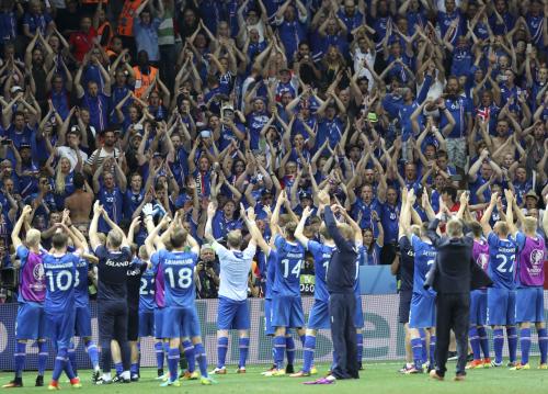 イングランドに勝利し、大勢のサポーターと喜びを分かちあうアイスランド代表イレブン（ＡＰ）