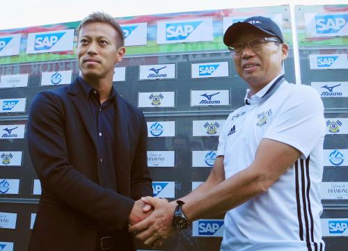 オーストリアで再会し、握手を交わすサッカー日本代表の本田（左）と岡田氏