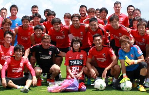 退職する平井さん（前列中央）と記念撮影する浦和の選手、スタッフ