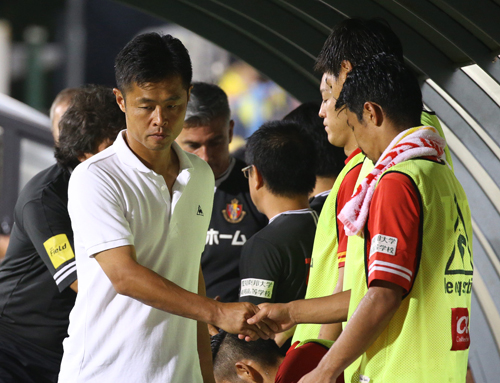 ２０日の柏戦で敗れ、厳しい表情で選手と握手する名古屋・小倉監督（左）