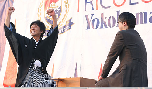 ２０１５年７月、Ｊ１の横浜―山形戦の試合前のイベントで郷田真隆王将（右）と公開対局を行い、勝利しガッツポーズを見せる元日本代表ＤＦの波戸康広氏