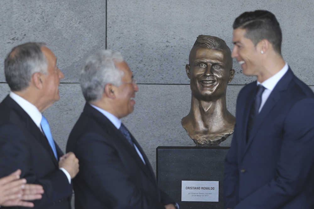 地元の空港に飾られた自分の像の前で笑顔を見せるＣ・ロナウド（右）