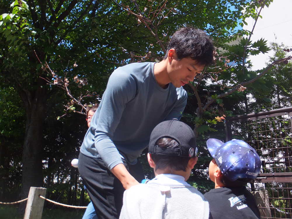 札幌市内の室内練習場で自主トレ後、子どものファンにサインする日本ハム・岡