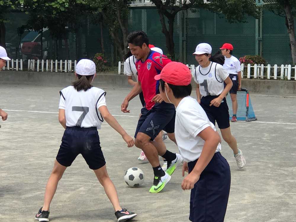 調布市内の小学校を訪れ、サッカーで児童とふれ合う大久保