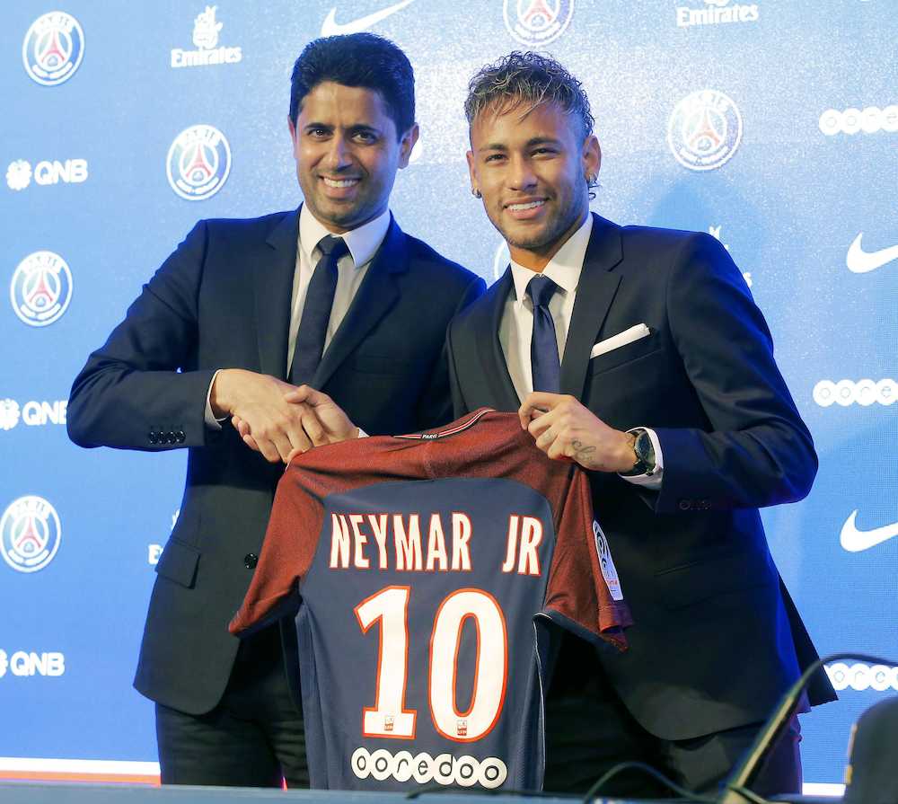 サッカーのフランス１部リーグ、パリ・サンジェルマンに移籍し、入団会見で背番号「１０」のユニホームを手にするネイマール選手（右）