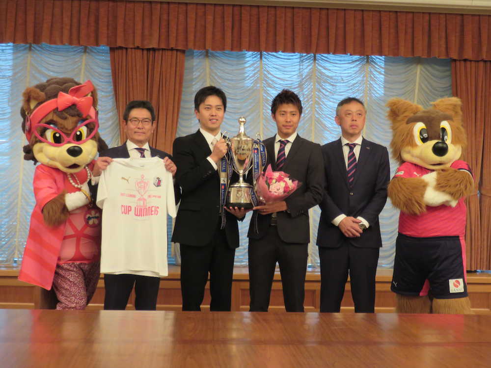 記念撮影をする（左から）マダム・ロビーナ、玉田社長、吉村・大阪市長、柿谷、大熊チーム統括部長、ロビー