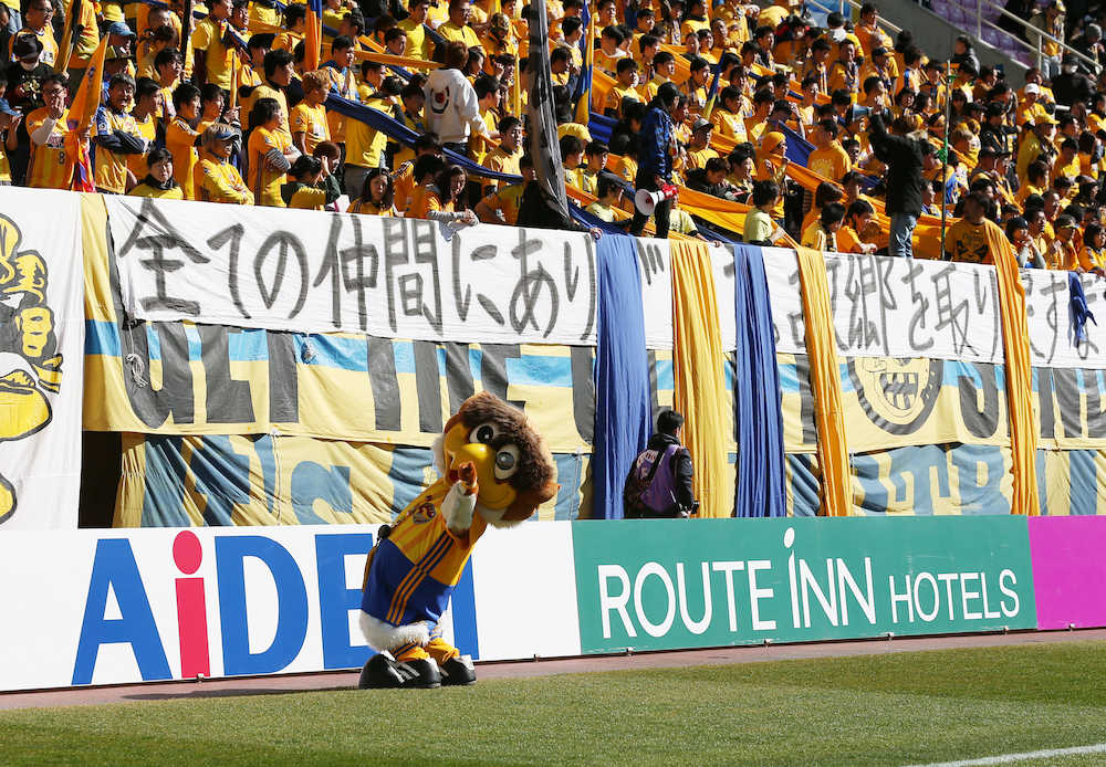 試合開始前、復興への強いメッセージが書かれた横断幕の下でポーズを決める仙台ベガッ太