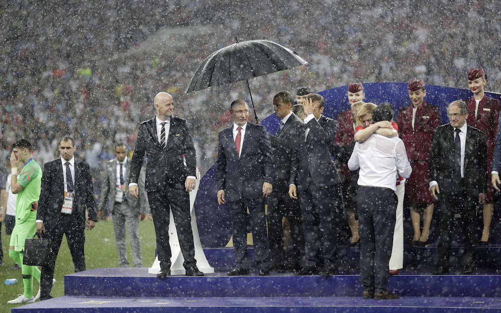 １人だけ傘に守られていた？ロシアのプーチン大統領（ＡＰ）