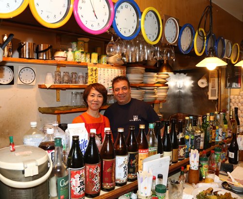 所狭しと食材や酒が並ぶ店内で笑顔を見せる店長のマンスール・コルドバッチェさん（右）と妻の門馬きよみさん