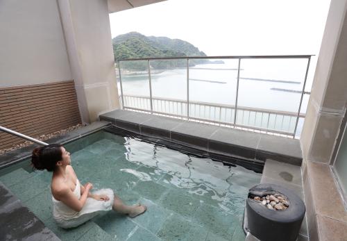 伊豆まつざき荘６階の露天風呂から景色を眺める祥子