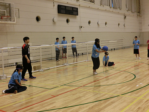学生たちはゴーグルをつけ、見えない状況の下でゴールボールのゲームを体験