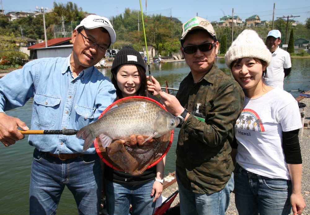 高山恵美子さん（中央）のおかげで今回の最大魚３８・５センチを釣り上げたアモーレ石上さんと未来夫人。左は筆者