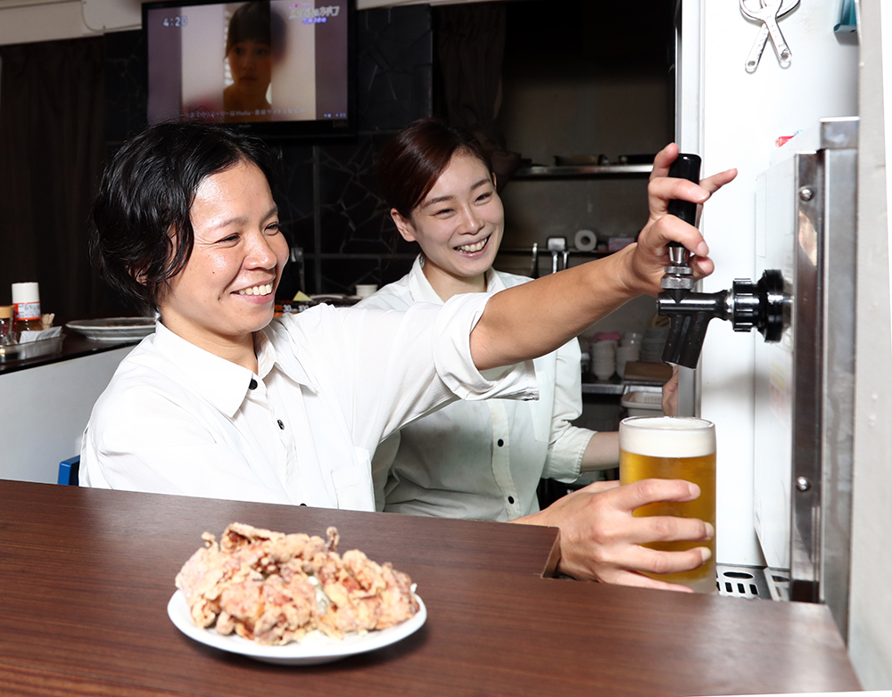 生ビールを注ぐ時田裕子店長（左）と宮内真里奈さん