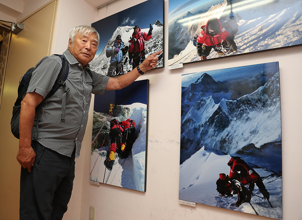 エベレスト登頂時の写真を指さす三浦氏