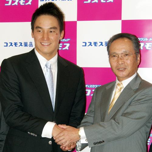 新しい所属先に決まったコスモス薬品の小野幸弘専務（右）と握手する競泳の松田丈志