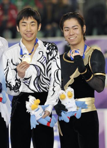 表彰式で笑顔を見せる優勝した織田信成（左）と３位の村上大介（フォート・キシモト提供）