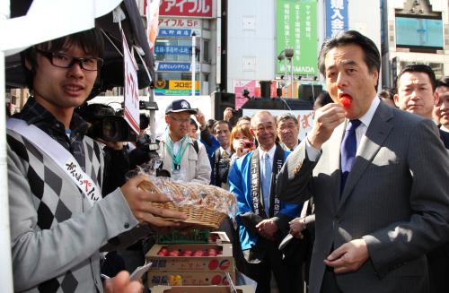 福島県産の野菜をＰＲする東洋大・柏原は視察に訪れた岡田幹事長（右）にトマトを勧める