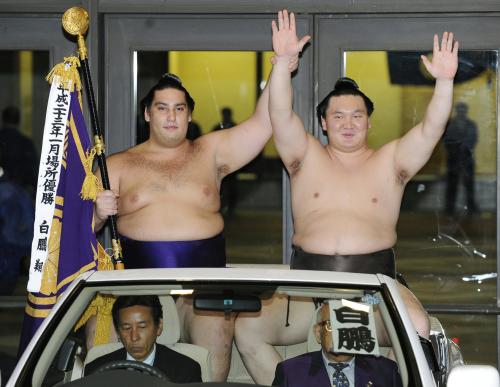 大相撲技量審査場所で７場所連続優勝を果たし、車上撮影会で万歳する横綱白鵬。左は敢闘賞の魁聖