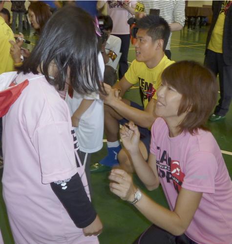 子どもたちにサインする女子マラソンの高橋尚子さん（手前）とサッカー日本代表ＧＫの川島永嗣選手