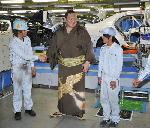 東日本大震災で被害を受けたトヨタ自動車の子会社、セントラル自動車の宮城工場を訪れ、震災で家族を亡くした従業員と握手する横綱白鵬関