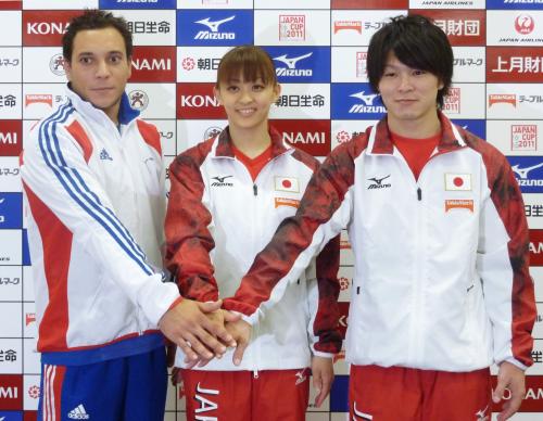 体操のジャパン・カップ記者発表で、手を重ね健闘を誓う内村航平（右）と田中理恵（中央）。左はトマ・ブーアイ