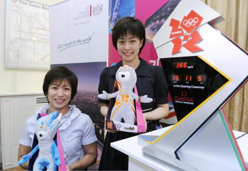 ロンドン五輪開幕まであと１年となり、披露されたカウントダウン時計（右）と記念撮影に納まる卓球の石川佳純と陸上、車いすの土田和歌子（左）