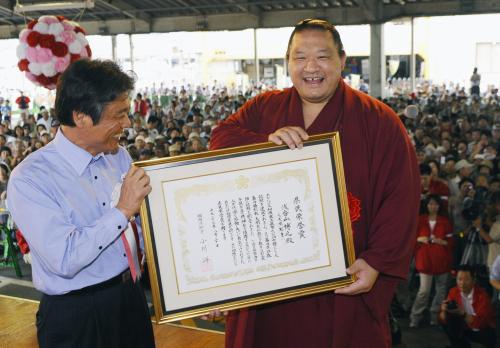 福岡県の小川洋知事（左）から県民栄誉賞が贈られ、笑顔を見せる元大関魁皇の浅香山親方