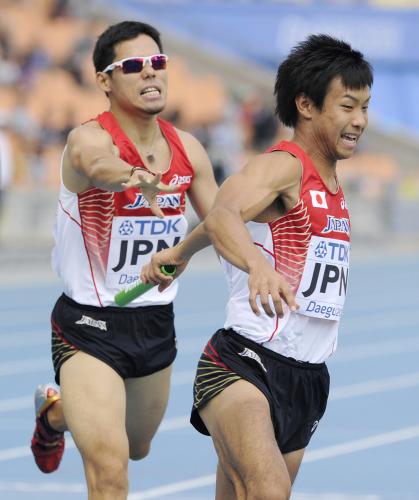 男子１６００メートルリレー予選で、第２走者の金丸（左）から石塚へのリレーで遅れる日本