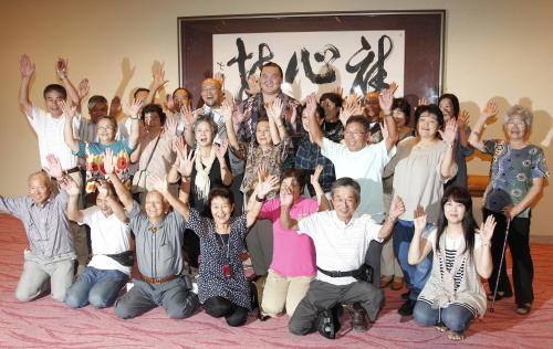 福島県双葉町の人たちと一緒に記念撮影にのぞみ、一同の万歳に笑顔を見せる白鵬