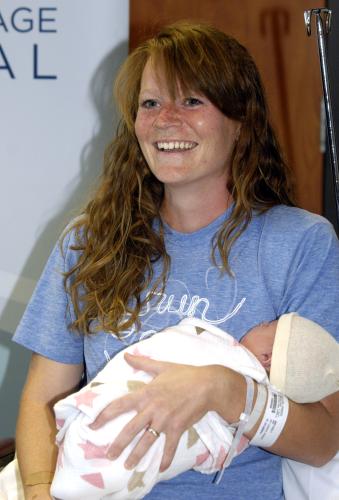 10日、米イリノイ州の病院で赤ちゃんを抱くアンバー・ミラーさん