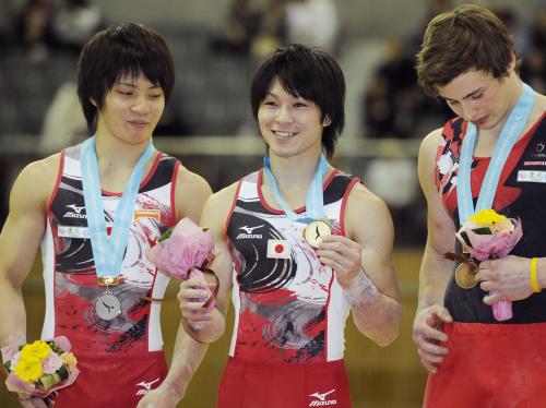 男子鉄棒で優勝し、表彰式でメダルを手に笑顔の内村航平（中央）。左は２位の田中佑典