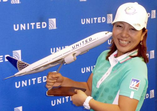 契約した航空会社の模型を手に笑顔を見せる宮里美香