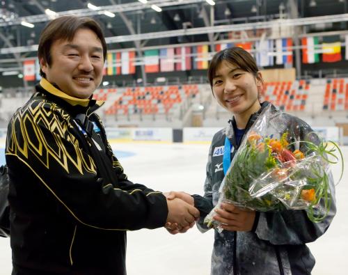 スピードスケート・ショートトラックのＷ杯で日本人初の総合優勝を果たし、杉尾憲一監督（左）と握手する酒井裕唯