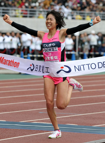 大阪国際女子マラソンで２時間２３分２３秒で優勝を飾り、両手を突き上げてゴールテープを切る重友梨佐＝１・２９＝