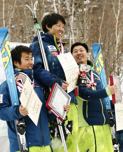 表彰台で笑顔を見せる男子大回転で優勝した大越龍之介（中央）。左は２位の成田秀将、右は３位の佐々木明