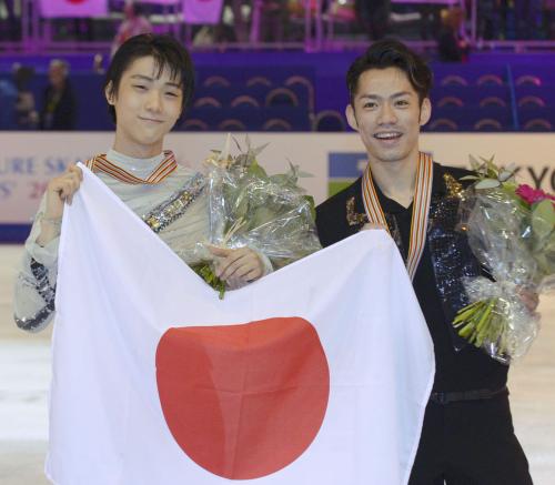 フィギュアスケートの世界選手権で、ダブルでメダルを獲得し、日の丸を手に笑顔で記念写真に納まる銀の高橋大輔（右）と銅の羽生結弦