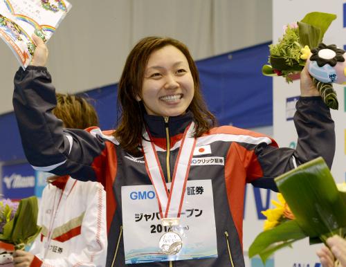 女子50メートルバタフライで日本新をマークして優勝し、表彰台で笑顔を見せる加藤ゆか