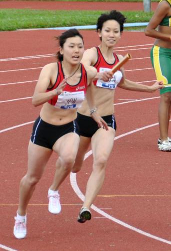 陸上のオセアニア選手権の女子４００メートルリレーで、アンカー・佐野（左）にバトンを渡す第３走者・福島