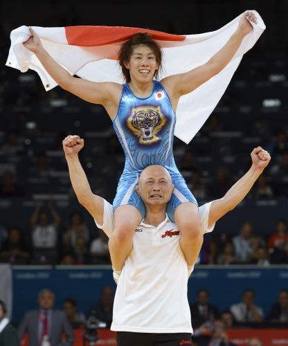女子55キロ級で優勝、栄和人監督に肩車され、日の丸を掲げる吉田沙保里
