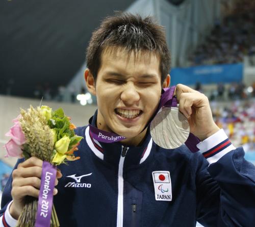 男子１００メートル平泳ぎ（ＳＢ11）で獲得した銀メダルを手に笑顔の木村敬一