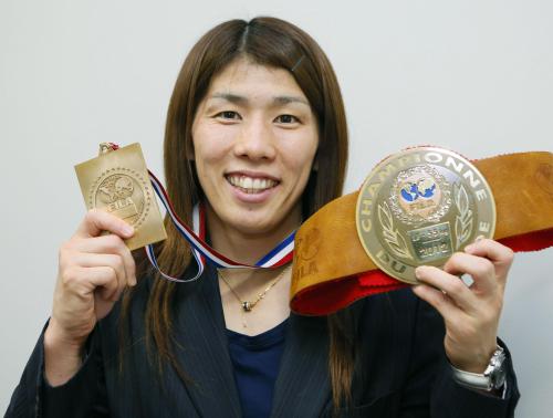 レスリングで前人未到の13大会連続世界一を達成し、金メダルと記念のベルトを手に笑顔を見せる吉田沙保里