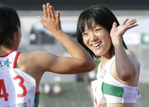 少年女子Ａ１００メートル決勝を11秒72で制し、２位の選手とタッチする土井杏南