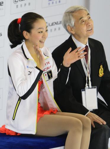 女子ＳＰの演技を終え笑顔を見せる浅田真央。右は佐藤信夫コーチ