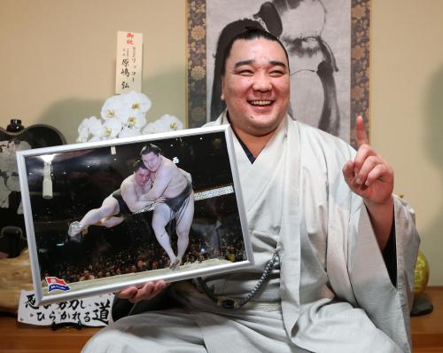 千秋楽で白鵬を寄り切った際の写真パネルを手に笑顔の日馬富士
