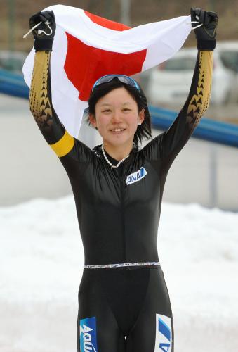 日本勢初の総合２連覇を果たし、日の丸を掲げ笑顔を見せる高木美帆