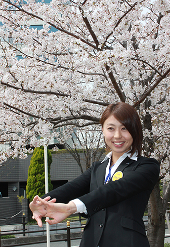 ミズノ大阪本社前の桜の木の下でポーズをとる市川