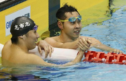 男子１００メートル平泳ぎで優勝し、２位の山口観弘（左）と握手する北島康介